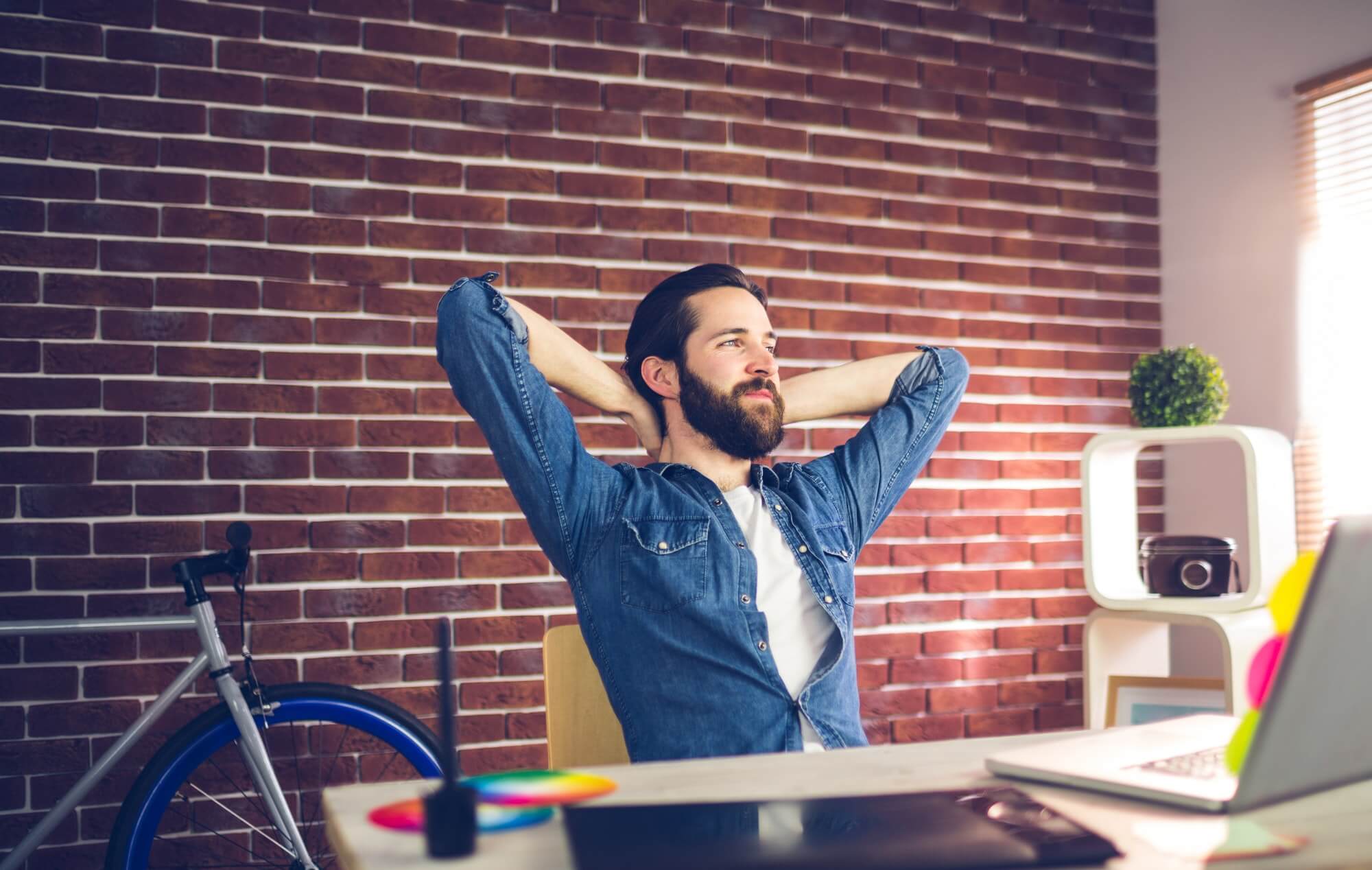 thoughtful-businessman-with-hands-behind-back-relaxing-in-creative-office-1.jpg